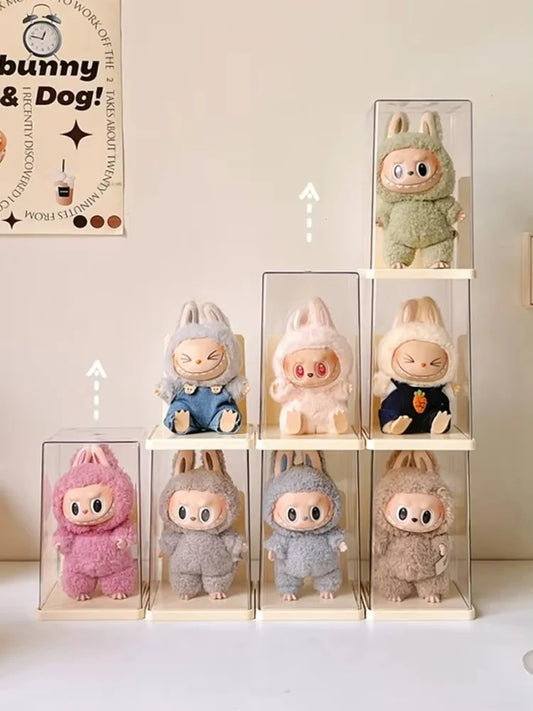 Collection of small plush toys in clear display cases on a white surface.